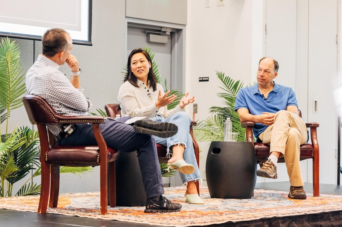 From left to right, Michael Fischbach, Priscilla Chan, and Steve Quake are seated on a stage. Steve and Michael look attentively at Priscilla as she speaks.