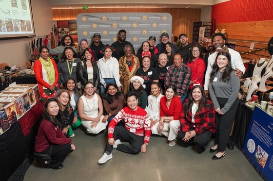 A group of people smile and pose in front of a backdrop that says, “Renaissance Entrepreneurship Center.”