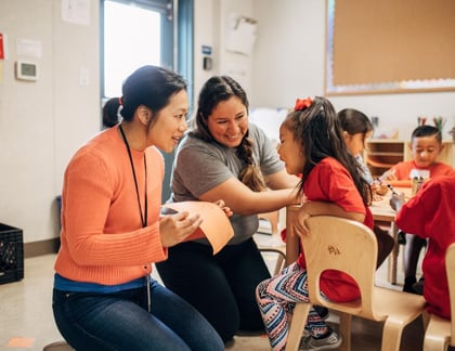 Image of Priscilla Chan speaking to a child and teacher at a school