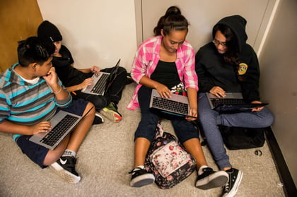 Image of kids sitting on floor using laptop computers.