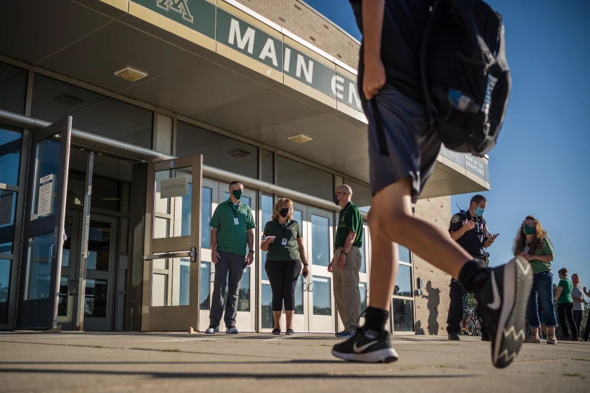 Image of a student walking into a school